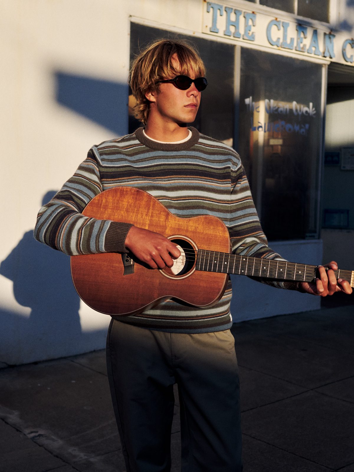 Katin Hitch Sweater in Tempest Blue, multicolor stripe knit, on model with a guitar, lifestyle #color_tempest blue