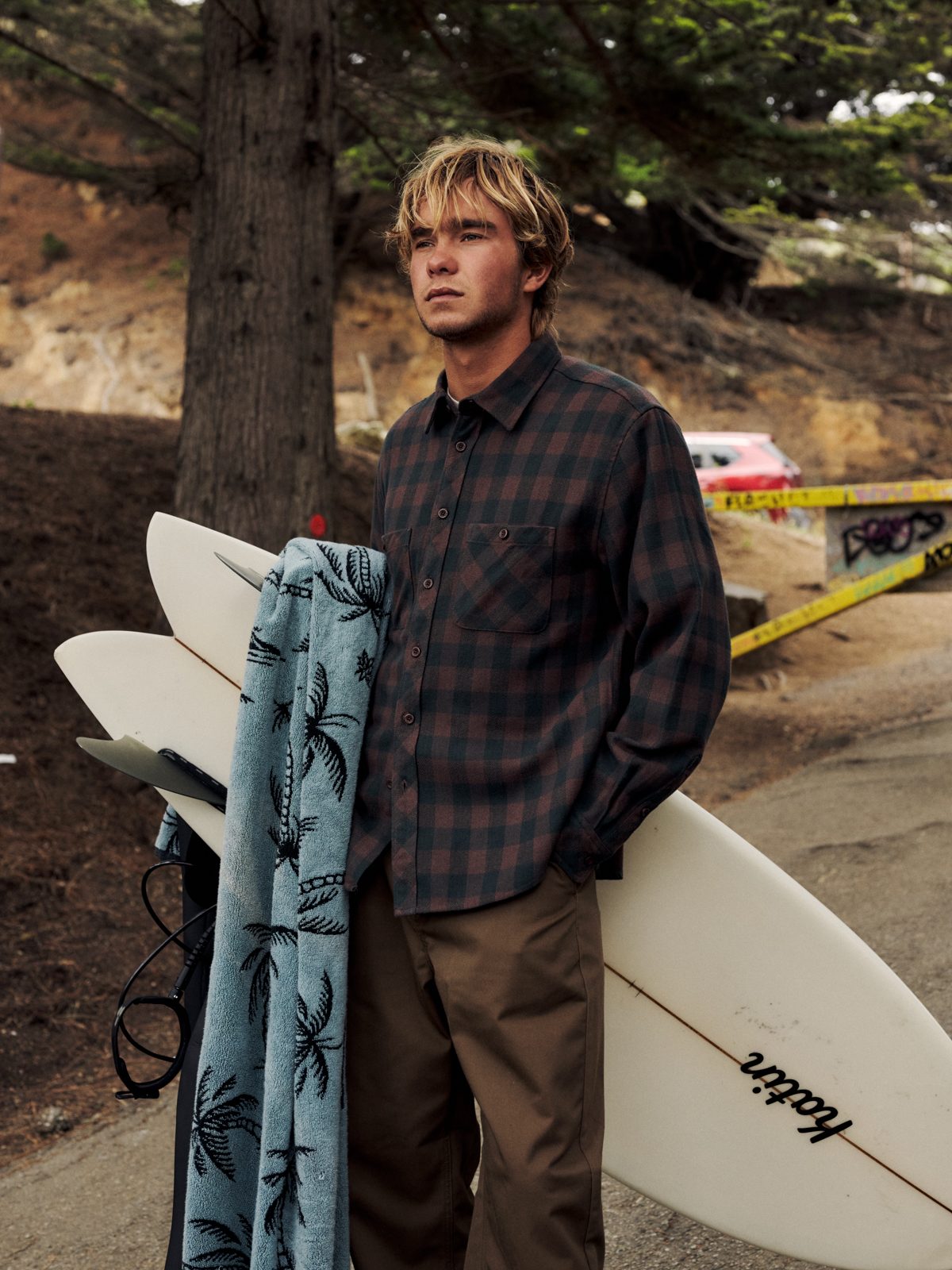 Katin Shiloh Flannel in French Roast Plaid heavyweight flannel, on model with surfboard, lifestyle #color_french roast plaid