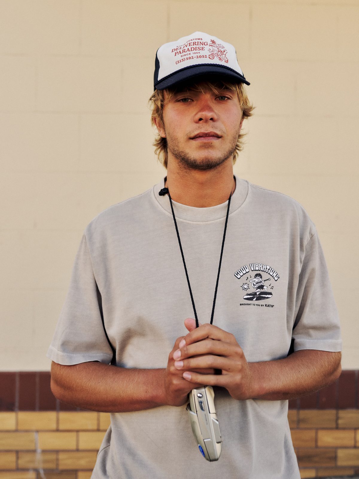 Katin Surf Rock Box Fit Tee in Cement heavyweight organic cotton, on model, front “Good Vibrations” graphic, lifestyle #color_cement vintage wash
